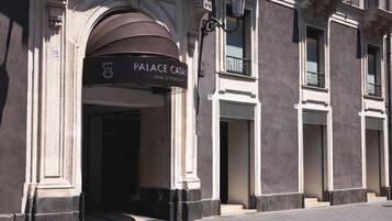 Entrada de un edificio con un letrero que dice 'PALACE CATANEO' y el número '216' indicando la dirección.