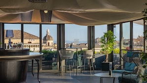 A rooftop bar with a view of a historic building and cityscape. - Palace Catania | UNA Esperienze (Catania)
