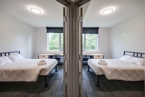A hotel room with two beds, a desk, and a chair. - Residence & Conference Centre - Oakville (Oakville)