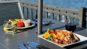 A table with a meal, a drink, and a view of the sea. - The Georgian Lakeside Resort (Lake George)
