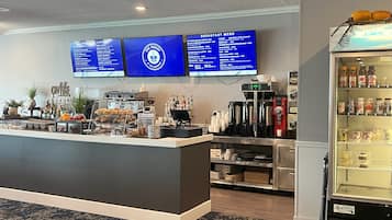 Un comptoir où l’on sert le petit-déjeuner, avec un menu, des machines à café et un distributeur de boissons.