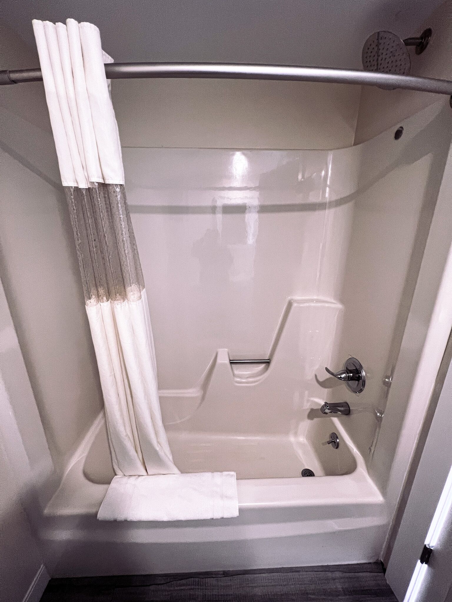 A modern bathroom with a bathtub, a shower, and a toilet.