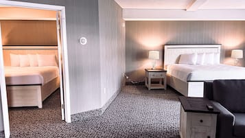 A hotel room with a bed, a chair, a nightstand, and a lamp.