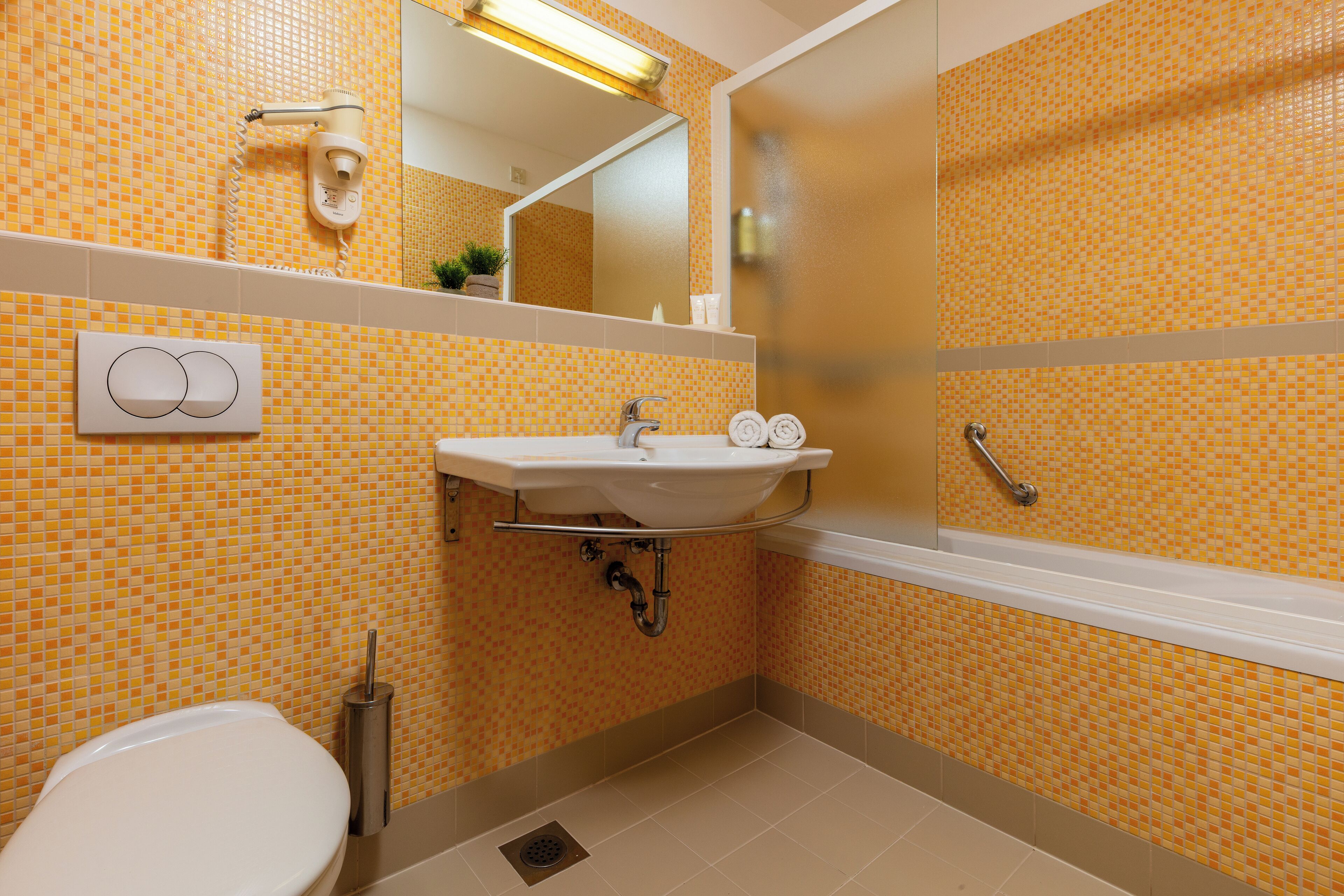 A bathroom with a white sink, a mirror, and a shower.