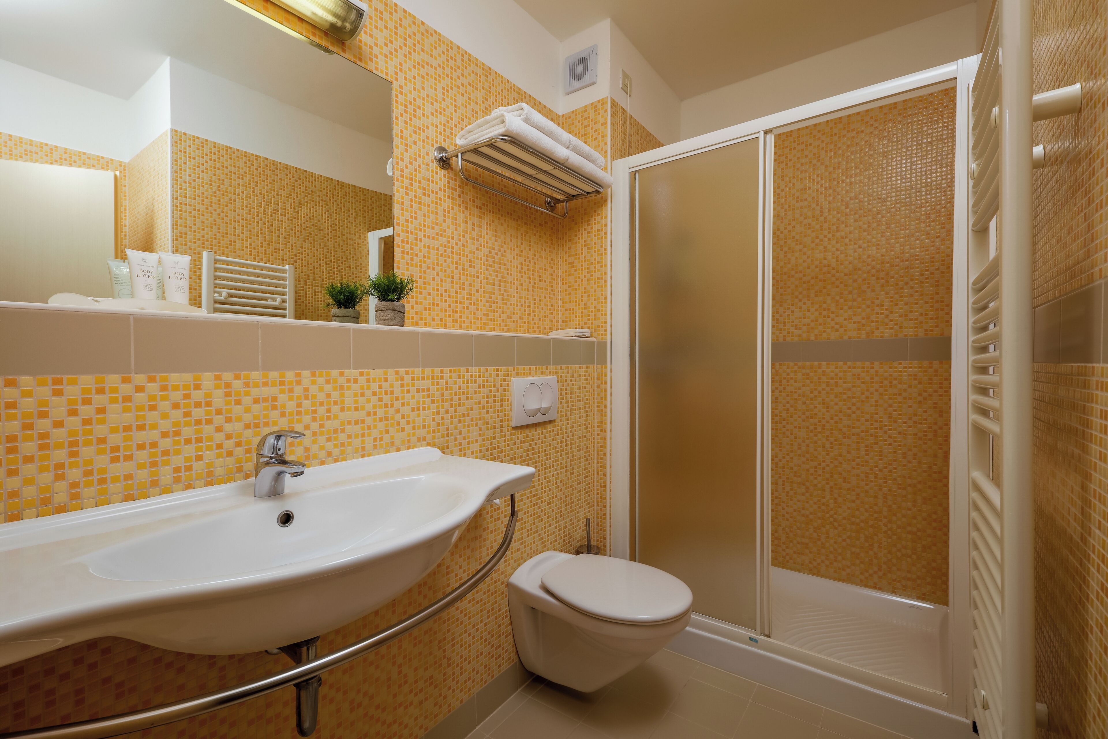 A bathroom with a sink, toilet, and shower.