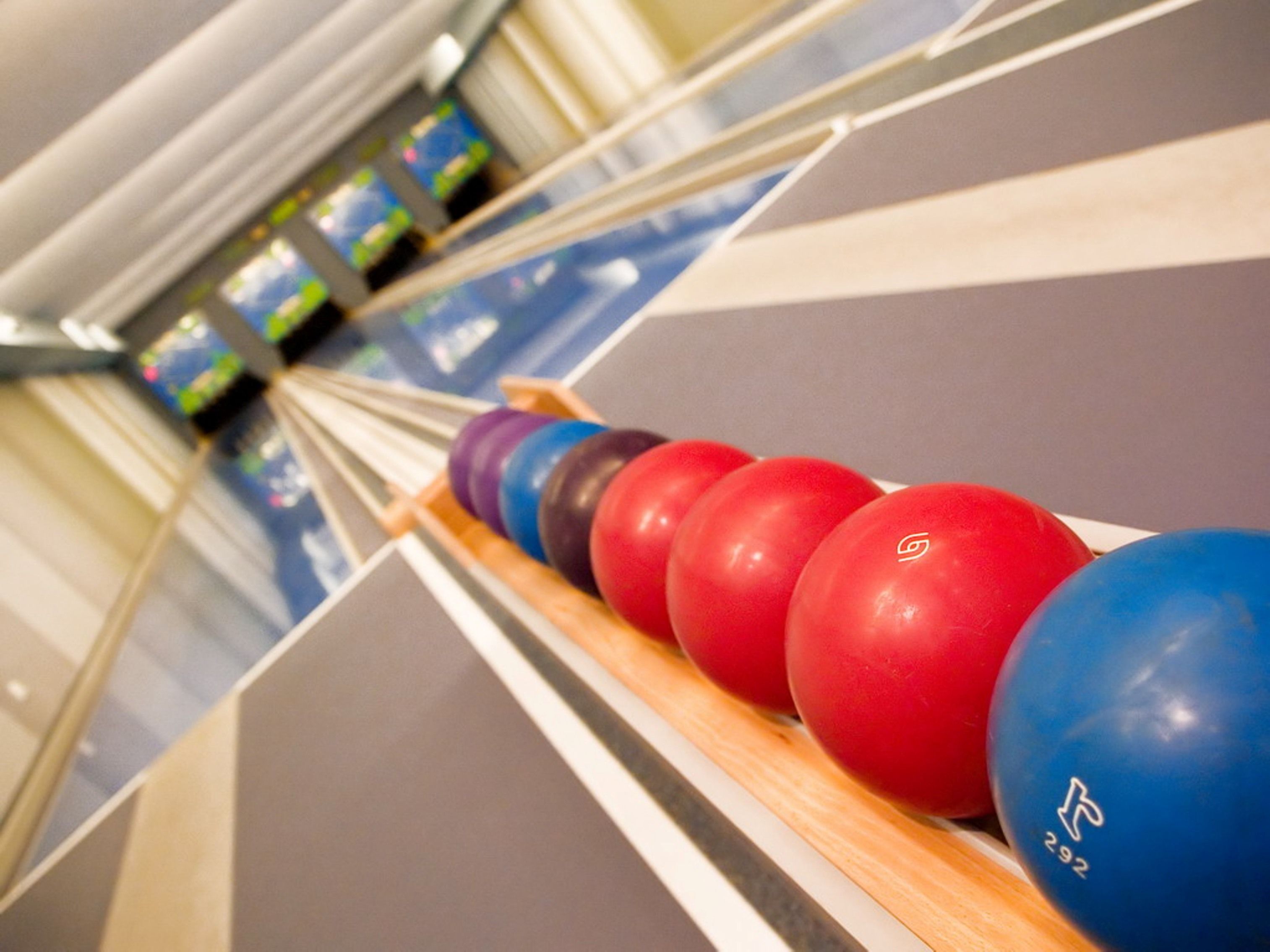 Una bolera con pistas y bolas de bolos.