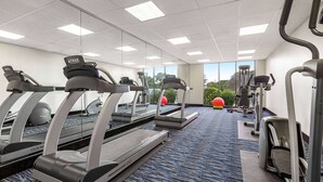 A gym with treadmills, elliptical machines, and exercise balls. - Ramada by Wyndham Marina (Marina)