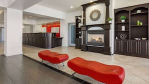 A spacious lobby with a fireplace, red seating, and a reception desk. - Ramada by Wyndham Marina (Marina)