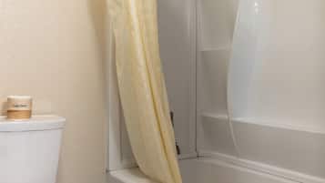 Une salle de bain avec des toilettes, un rideau de douche et une baignoire.