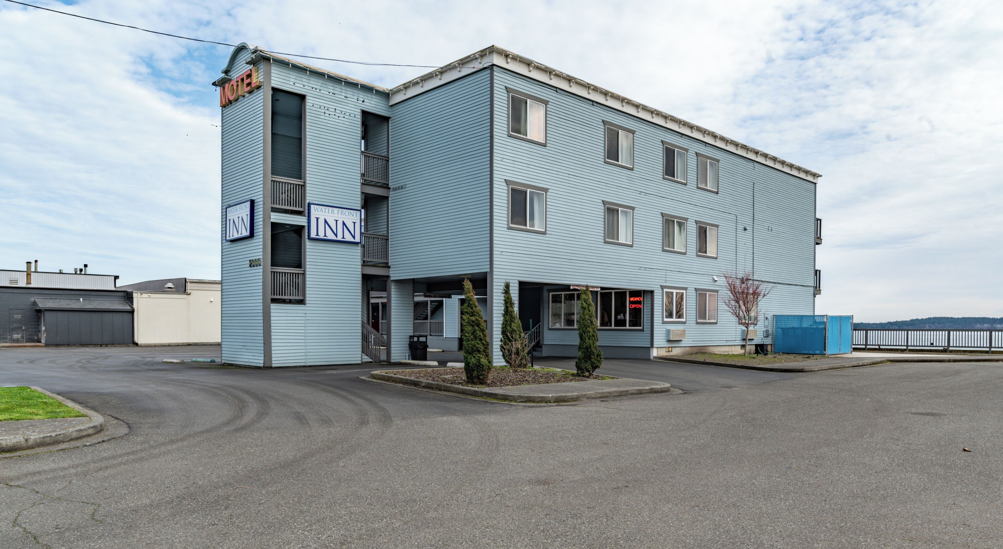 Un motel à deux étages, dont l’enseigne extérieure indique « Water Front Inn » et « Motel ».