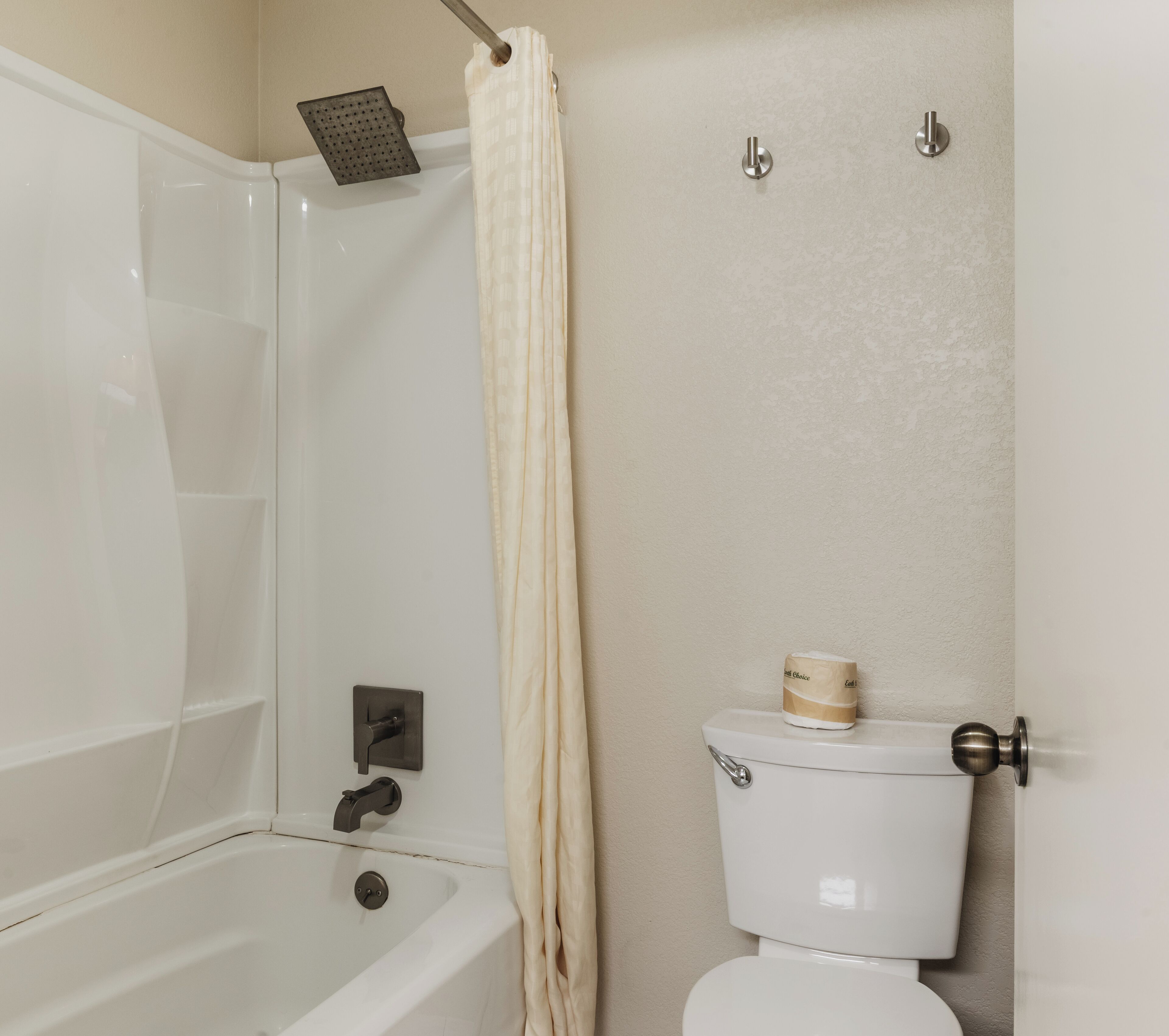 A bathroom with a bathtub, toilet, and shower.