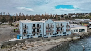 A multi-story building with balconies, located near a waterfront. - Water Front Inn (Port Townsend)