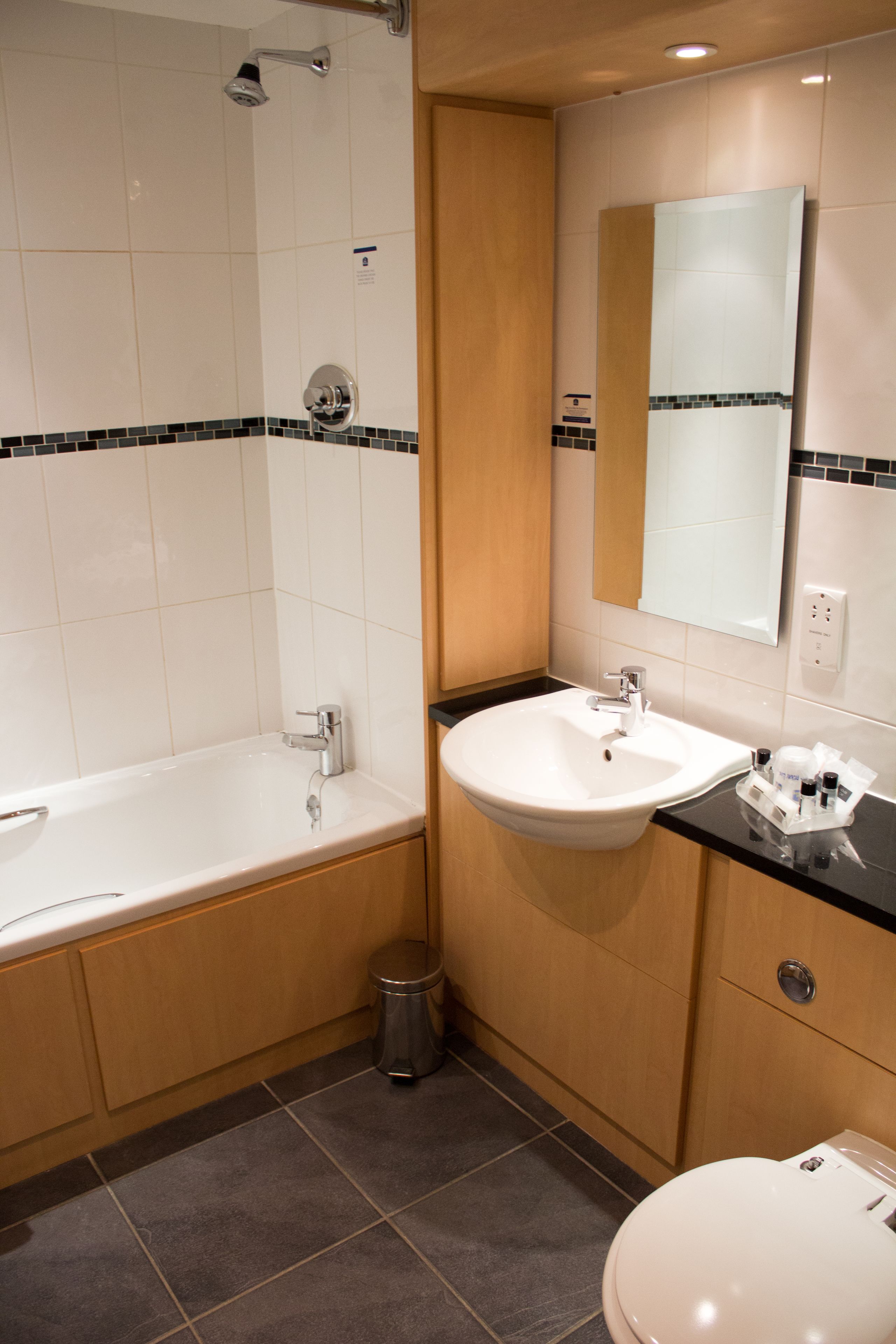 A modern bathroom with a bathtub, sink, and toilet.