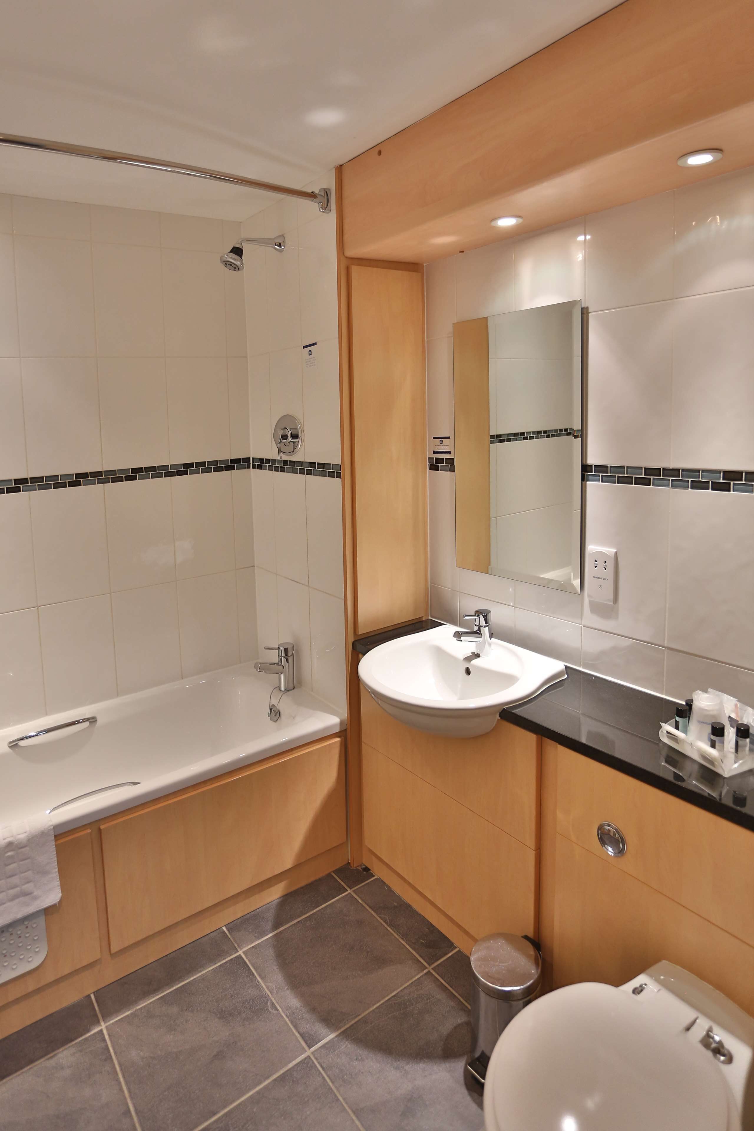 Een moderne badkamer met een bad, wastafel en toilet.