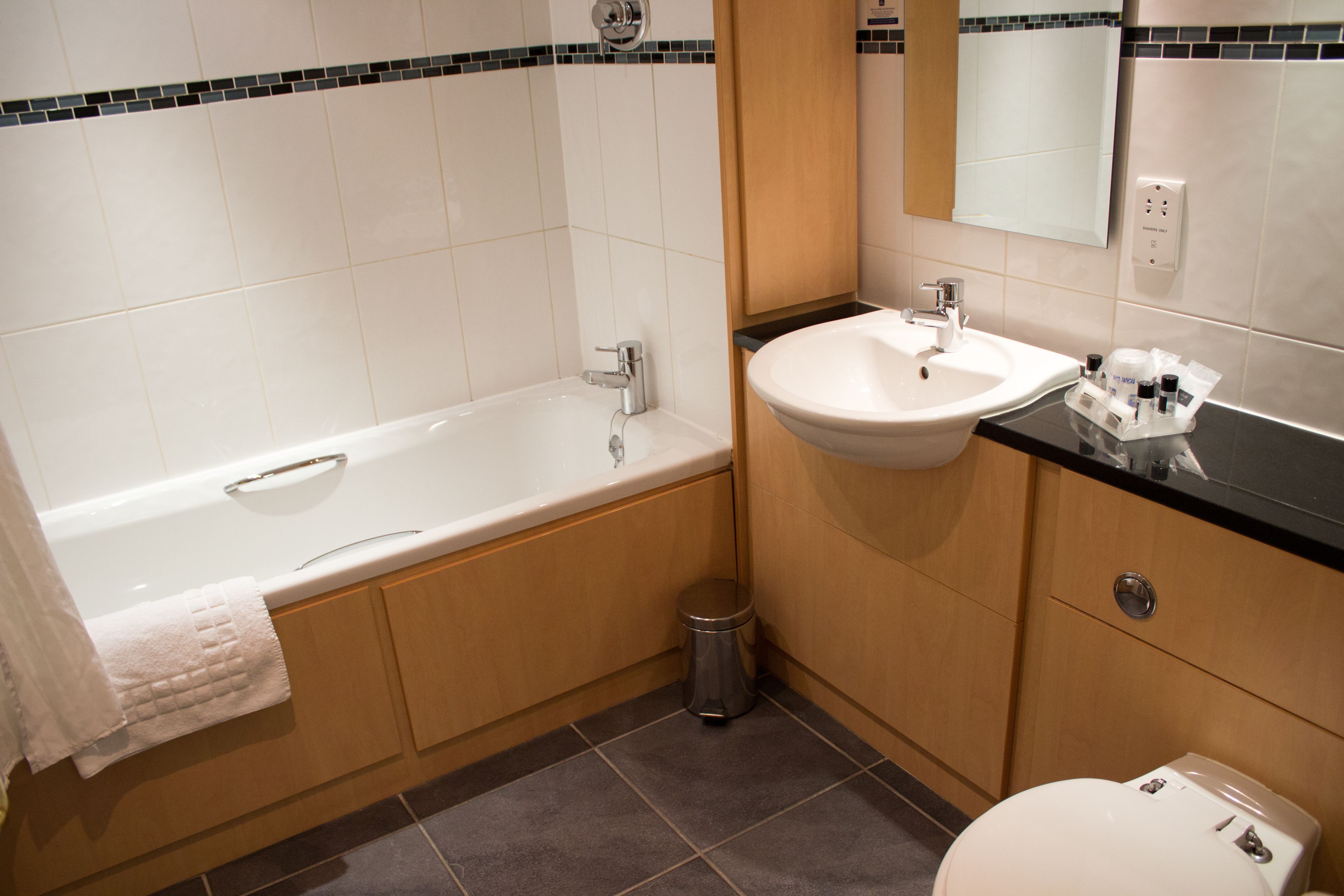 A modern bathroom with a bathtub, sink, and toilet.