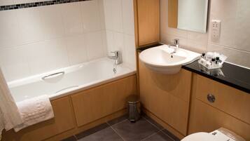 A modern bathroom with a bathtub, sink, and toilet.