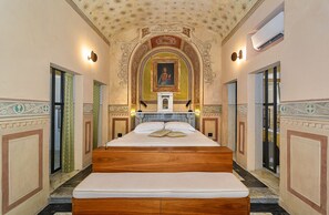 A large, centrally positioned bed with a wooden headboard, flanked by two doors on either side. - Albergo Villa Marta (Lucca)