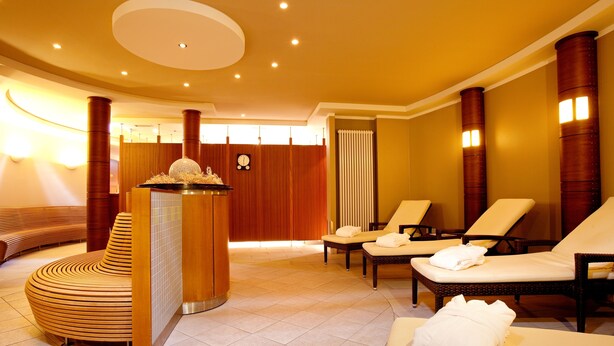 Une salle de spa comprenant un comptoir d’accueil, des fauteuils et un fauteuil de massage.