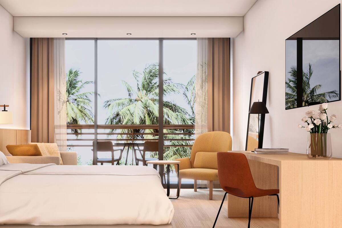 A modern hotel room with a large bed, a desk, and a balcony with a view of palm trees.