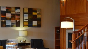 A spacious living area with a wooden staircase, a coffee station, and a fireplace. - Country Inn & Suites by Radisson, BWI Airport (Baltimore), MD (Linthicum Heights)
