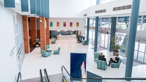 A spacious lobby with a reception desk, seating area, and large windows. - Coast Hotel & Convention Centre Langley City (Langley)