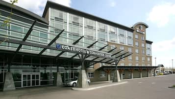 A hotel with a modern design, featuring a covered entrance and a sign that reads "Coast Hotel & Convention Centre".