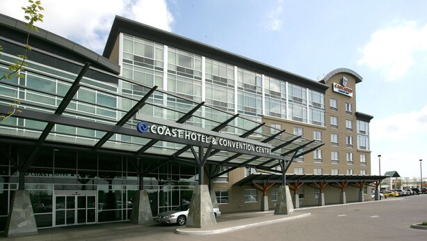 A hotel with a modern design, featuring a covered entrance and a sign that reads "Coast Hotel & Convention Centre". - Coast Hotel & Convention Centre Langley City (Langley)