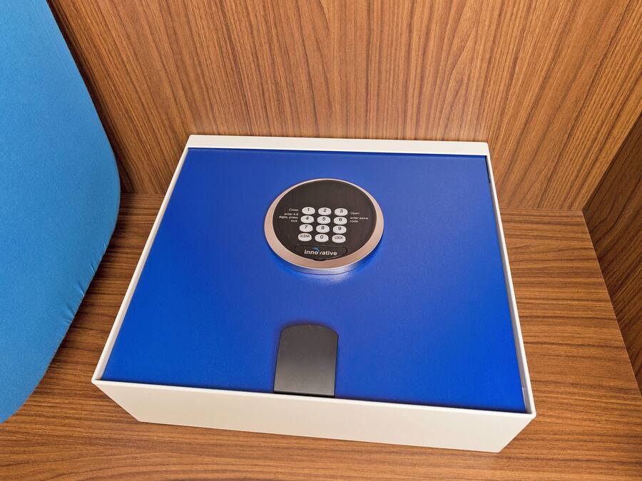 Een blauwe doos met een afstandsbediening erop, op een houten ondergrond.