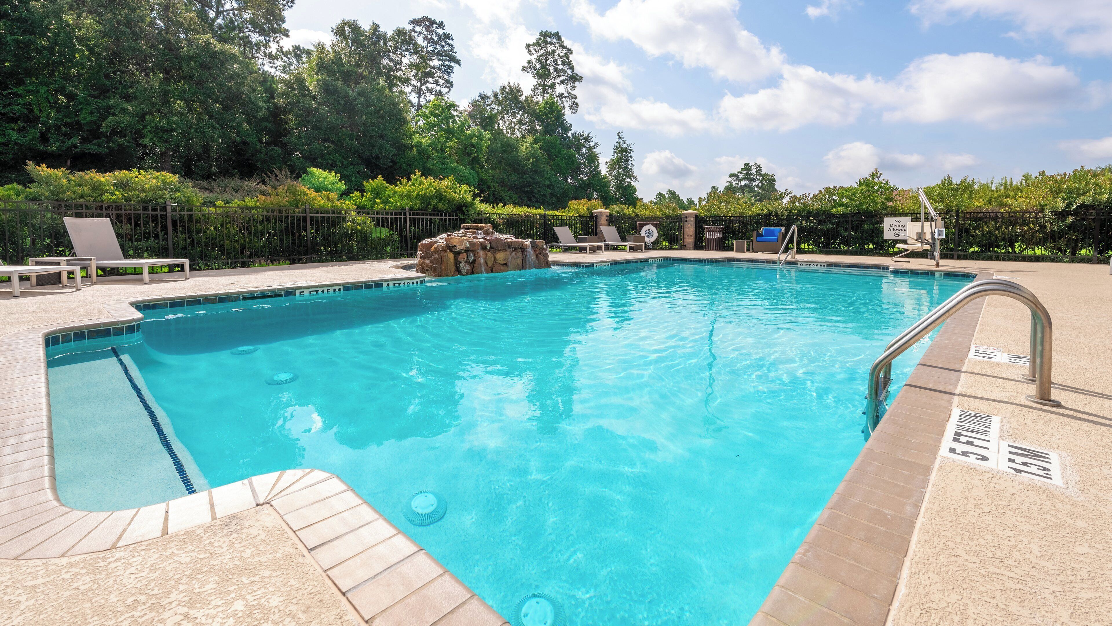 Una piscina al aire libre, sillones reclinables de piscina