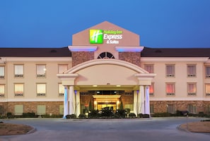 A Holiday Inn Express & Suites hotel with a brick facade, multiple windows, and a well-lit entrance. - Holiday Inn Express Hotel & Suites Conroe I-45 North by IHG (Conroe)