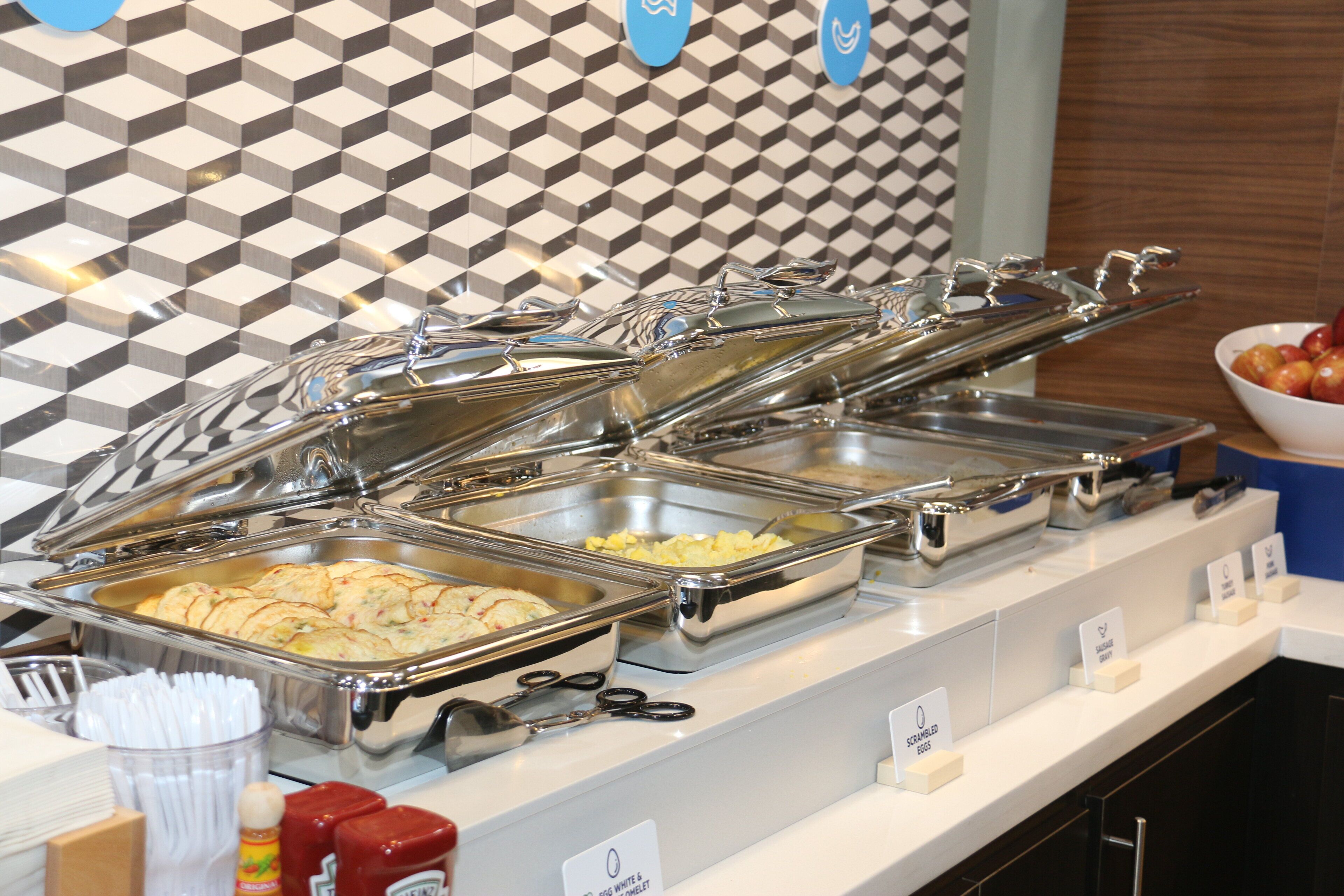 Una mesa de buffet con diversos alimentos y utensilios.