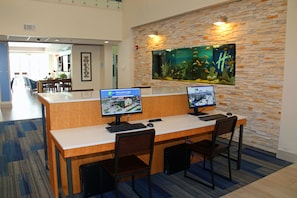 A reception desk with two monitors, a large aquarium, and a modern interior design.