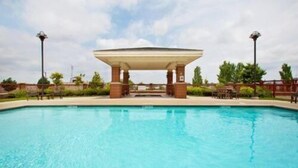 A swimming pool with a gazebo structure in the middle, surrounded by greenery and a clear sky. - Country Inn & Suites by Radisson, Springfield Downtown (Springfield)
