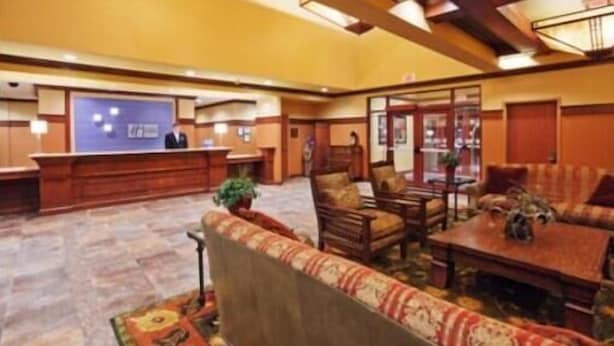 A hotel lobby with a reception desk, seating area, and a large window. - Country Inn & Suites by Radisson, Springfield Downtown (Springfield)