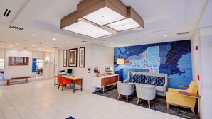 A modern hotel lobby with a large map mural, seating areas, and a reception desk. - Holiday Inn Express Hotel & Suites Chester by IHG (Chester)