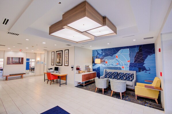 A modern hotel lobby with a large map mural, seating areas, and a reception desk. - Holiday Inn Express Hotel & Suites Chester by IHG (Chester)