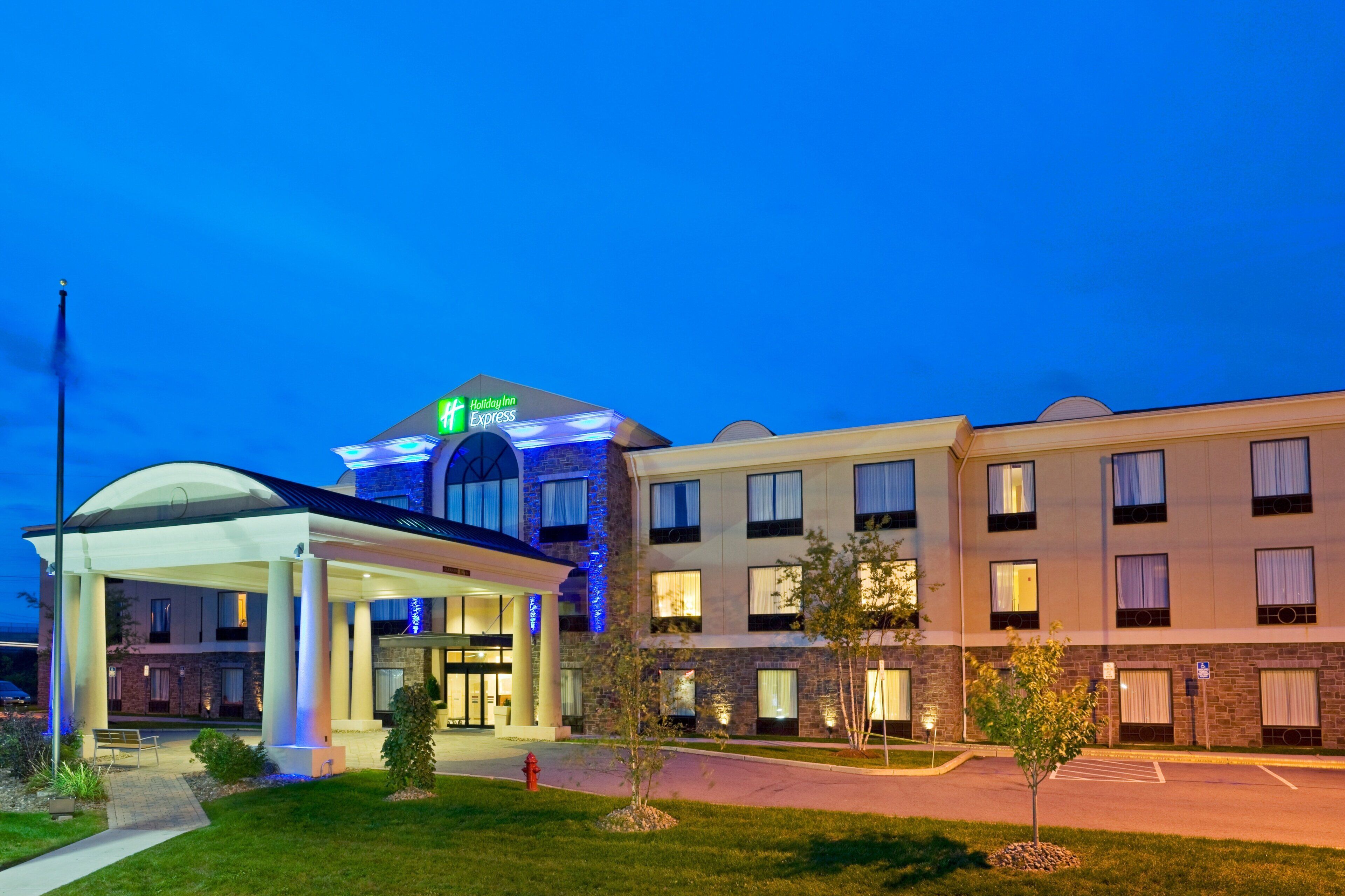 A Holiday Inn Express hotel with a covered entrance, a parking lot, and a well-lit facade.
