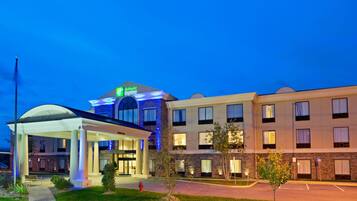 A Holiday Inn Express hotel with a covered entrance, a parking lot, and a well-lit facade.
