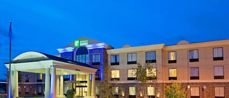 A Holiday Inn Express hotel with a covered entrance, a parking lot, and a well-lit facade.