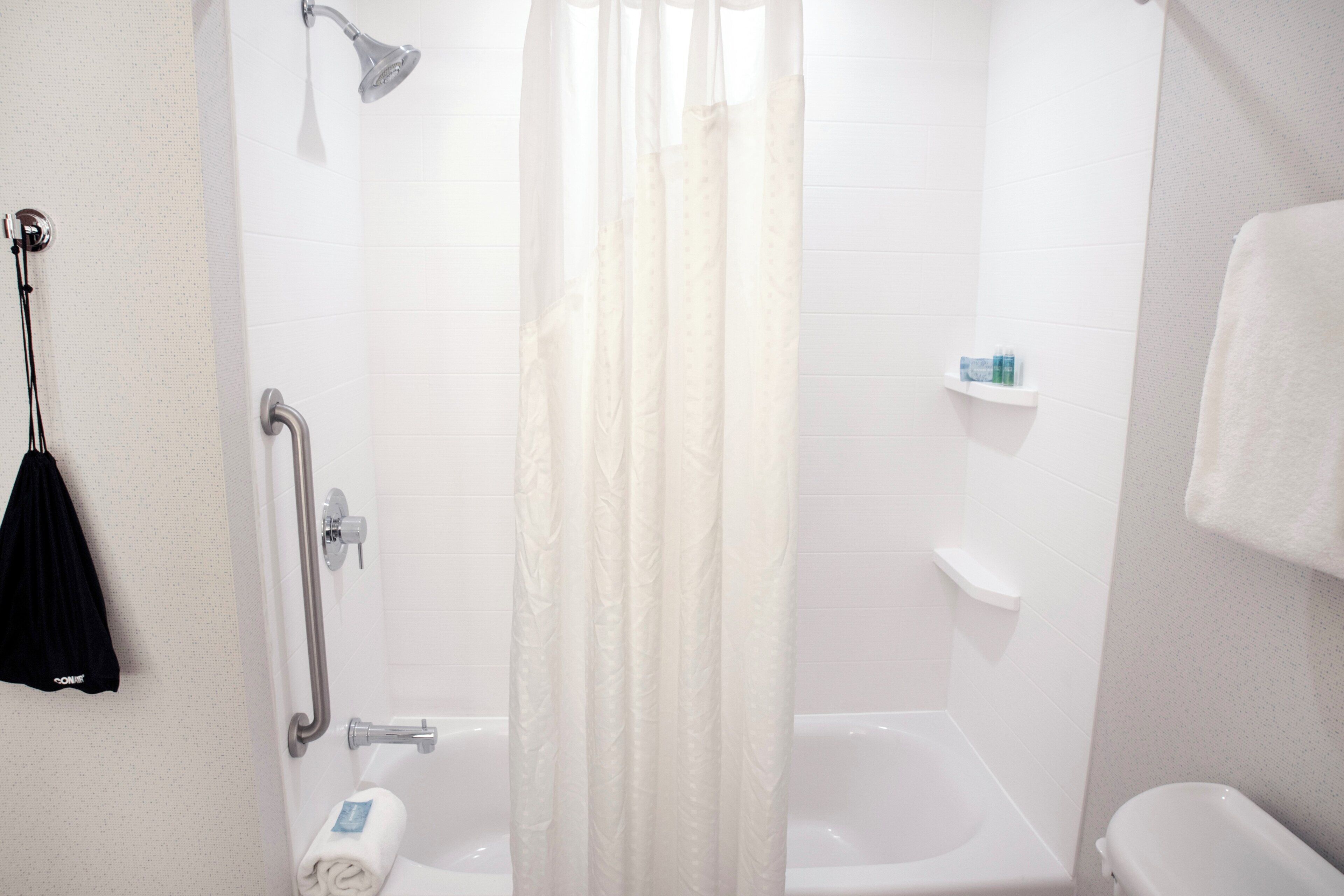 A bathroom with a shower, a toilet, and a bathtub.