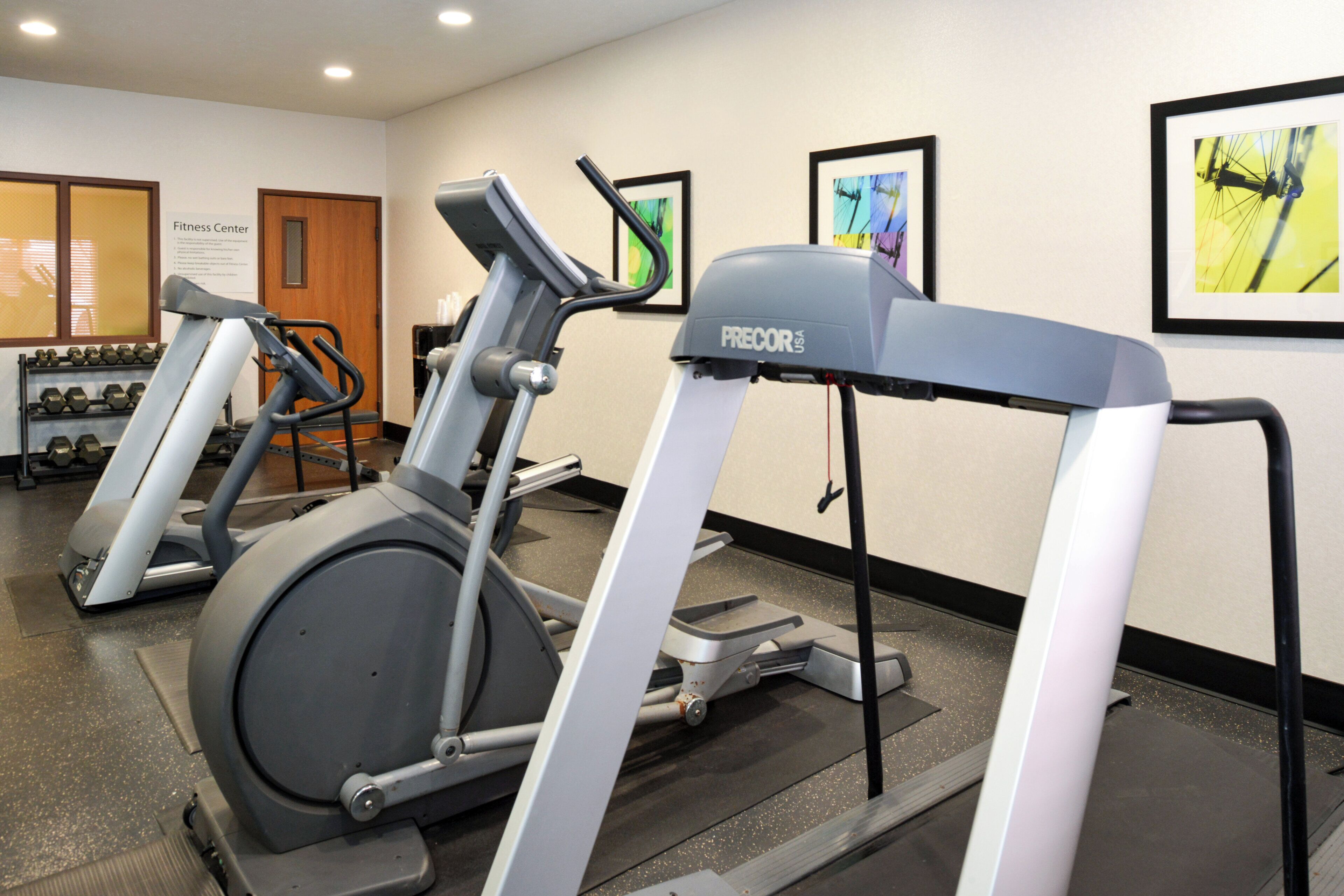 A fitness center with treadmills and dumbbells.