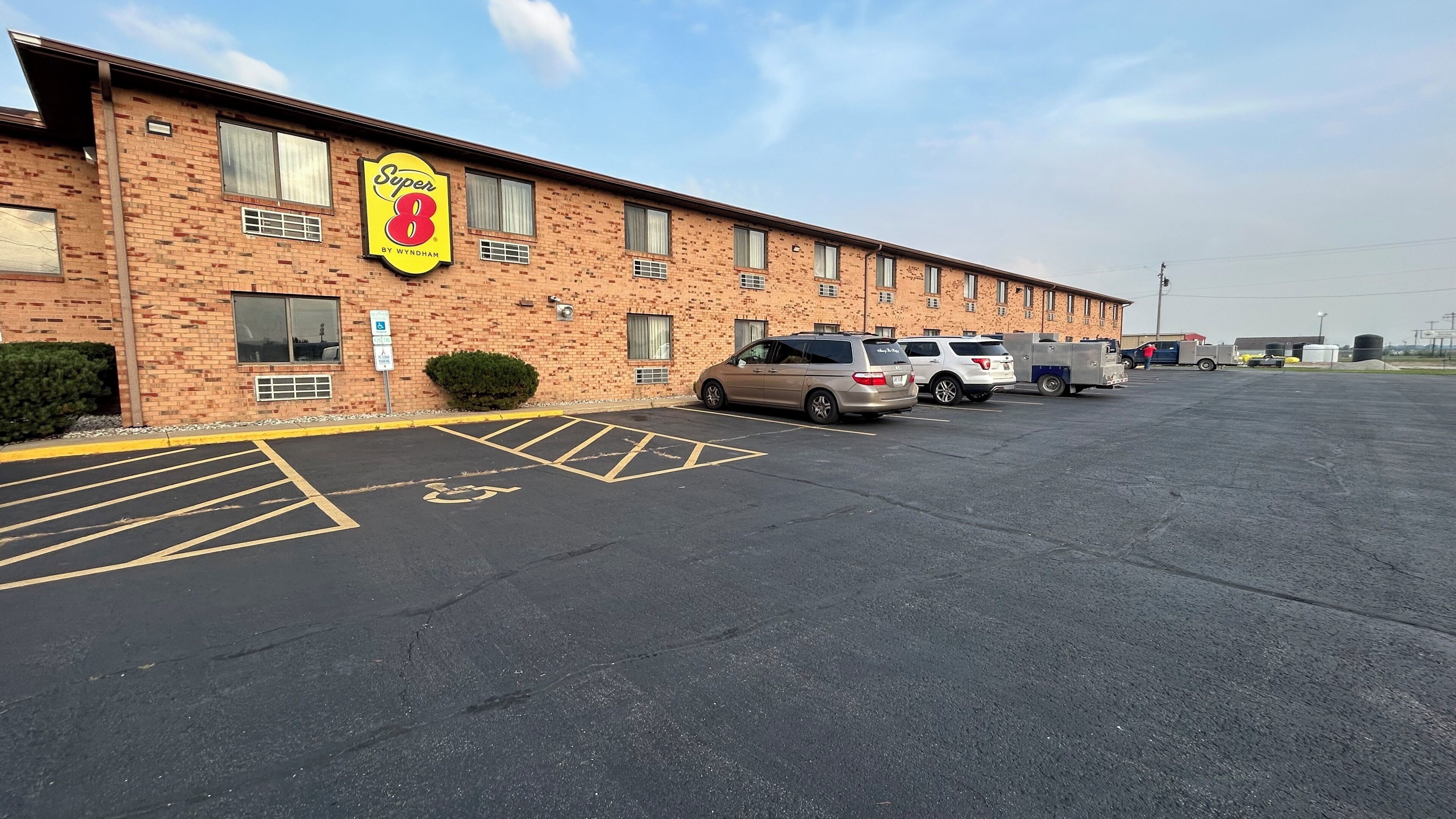 A parking lot with a Super 8 by Wyndham hotel in the background.