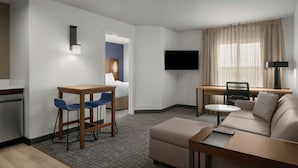 A modern hotel room with a sofa, a dining table, a TV, and a small kitchen area. - Residence Inn by Marriott Boise West (Boise)