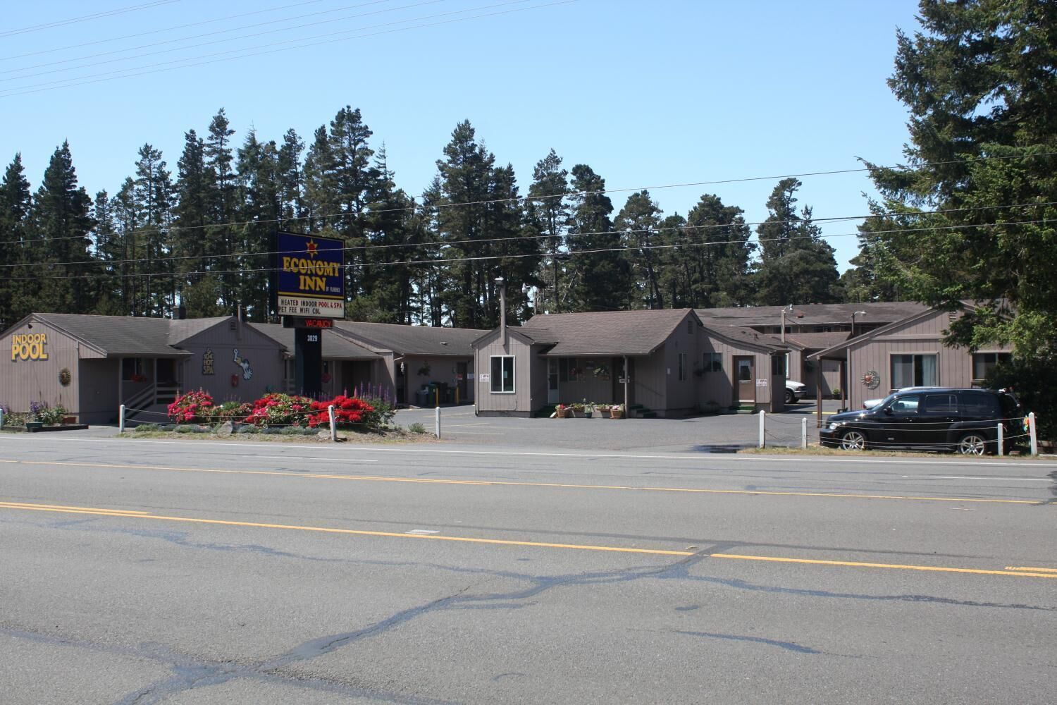 A motel with a sign for 'Economy Inn' and 'Indoor Pool'.