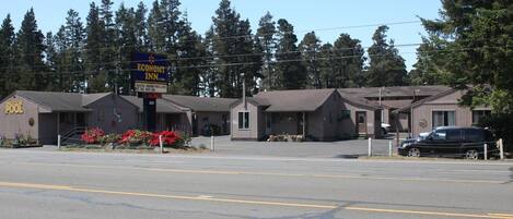 A motel with a sign for 'Economy Inn' and 'Indoor Pool'.