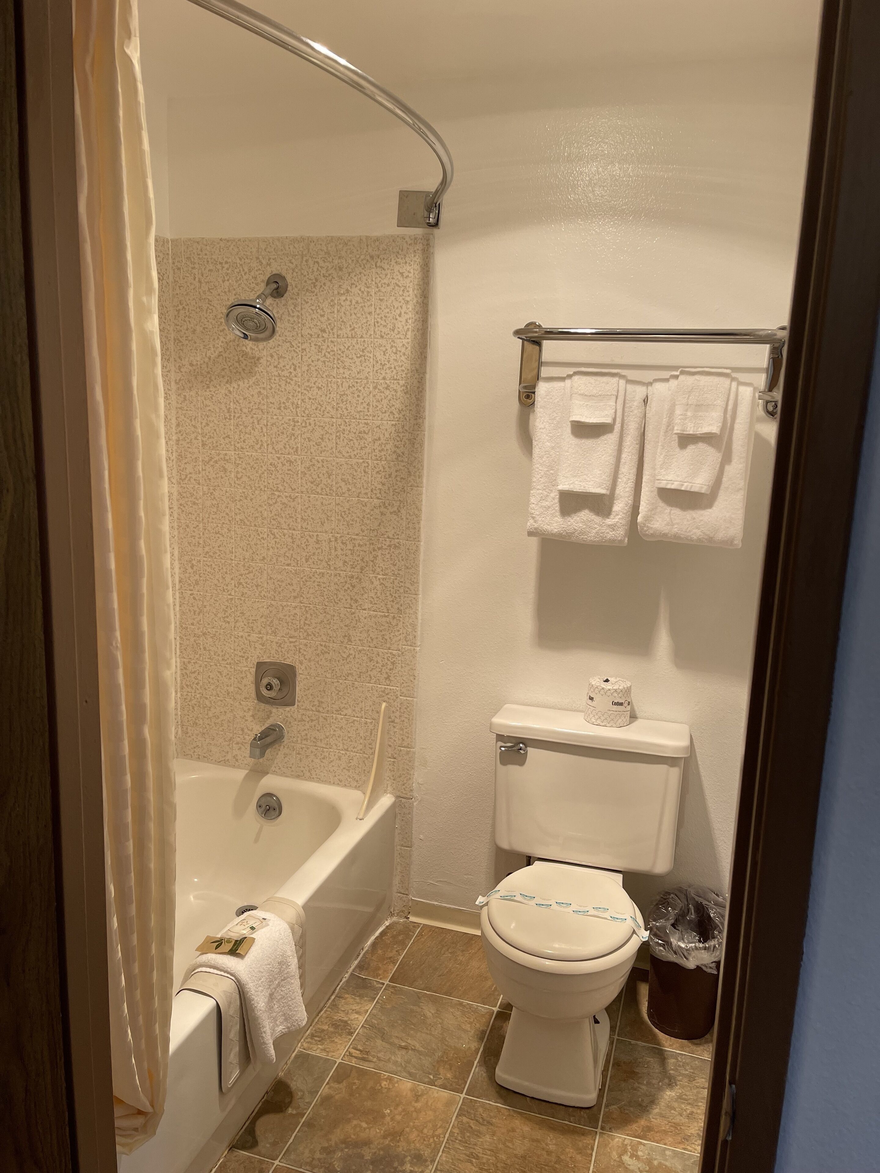 A bathroom with a bathtub, toilet, and towel rack.