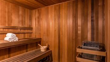 Una sauna de fusta amb bancs i un banc amb tovalloles.