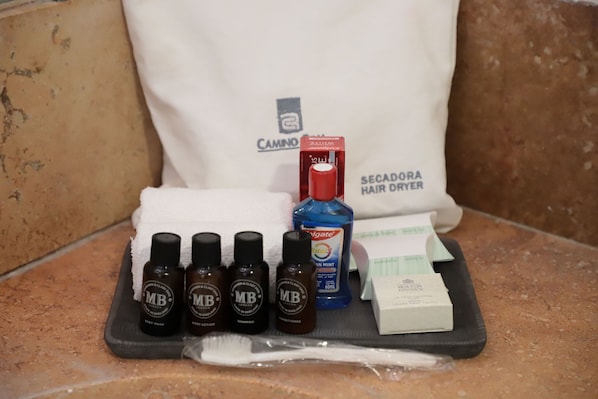 Toiletries and a hair dryer on a tray.
