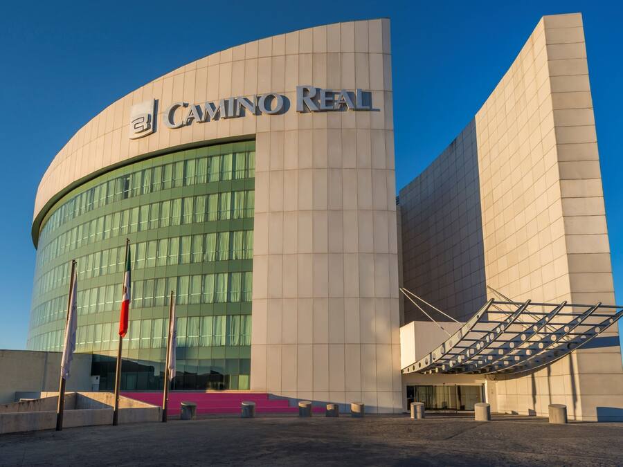 A modern building with the sign "CAMINO REAL" on the facade.