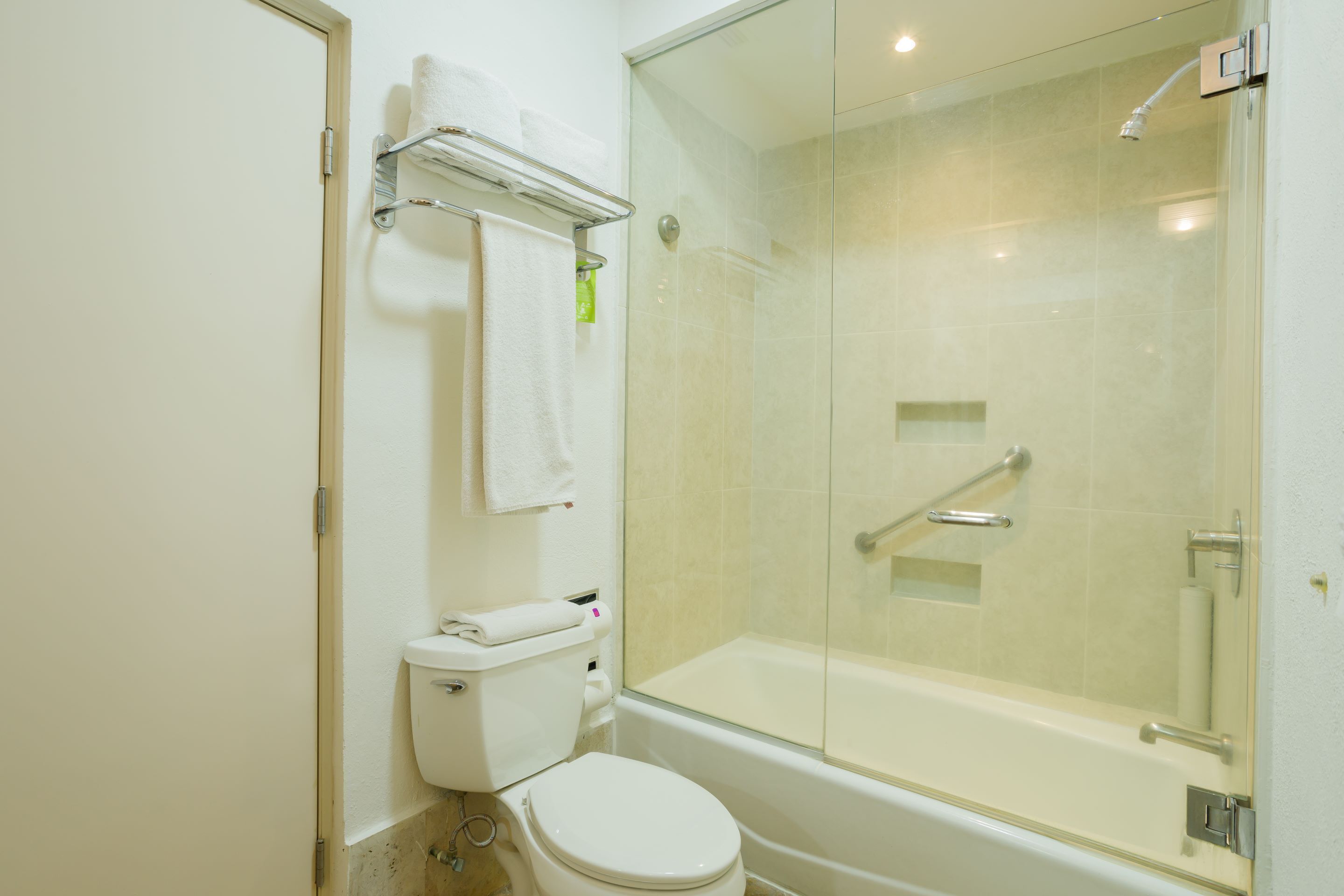 Un baño moderno con ducha envuelta en vidrio, inodoro y bañera.